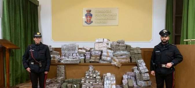 carabinieri davanti a panetti di droga sequestrati